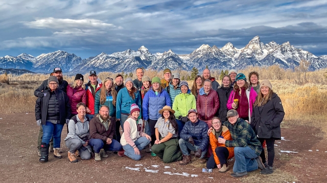 A group of course participants stands in front of a dramatic Idaho mountain vista.